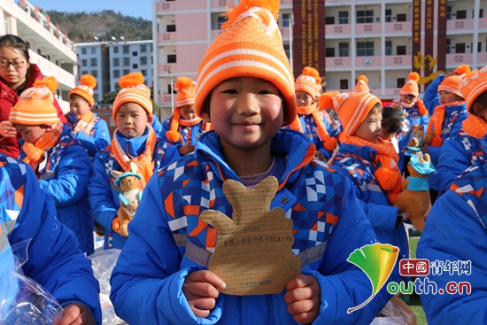 穿雨鞋的小女孩儿展示自己的“微心愿”。石泉县团委 供图 穿雨鞋的小女孩儿展示自己的“微心愿”。石泉县团委 供图